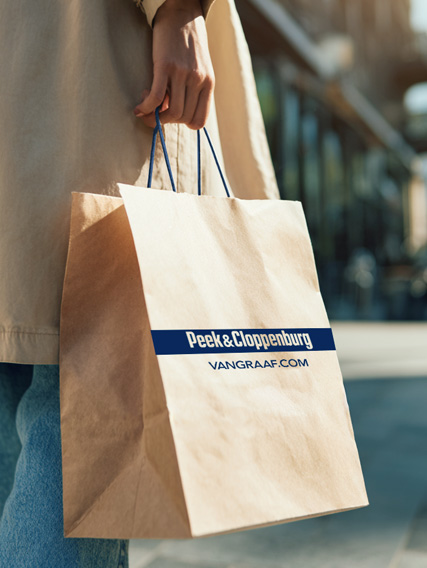 umwelt_topic_slider_tuete_427x568 Eine Person hält eine braune Papiertüte mit dem Logo "Peek & Cloppenburg" und der URL vangraaf.com.